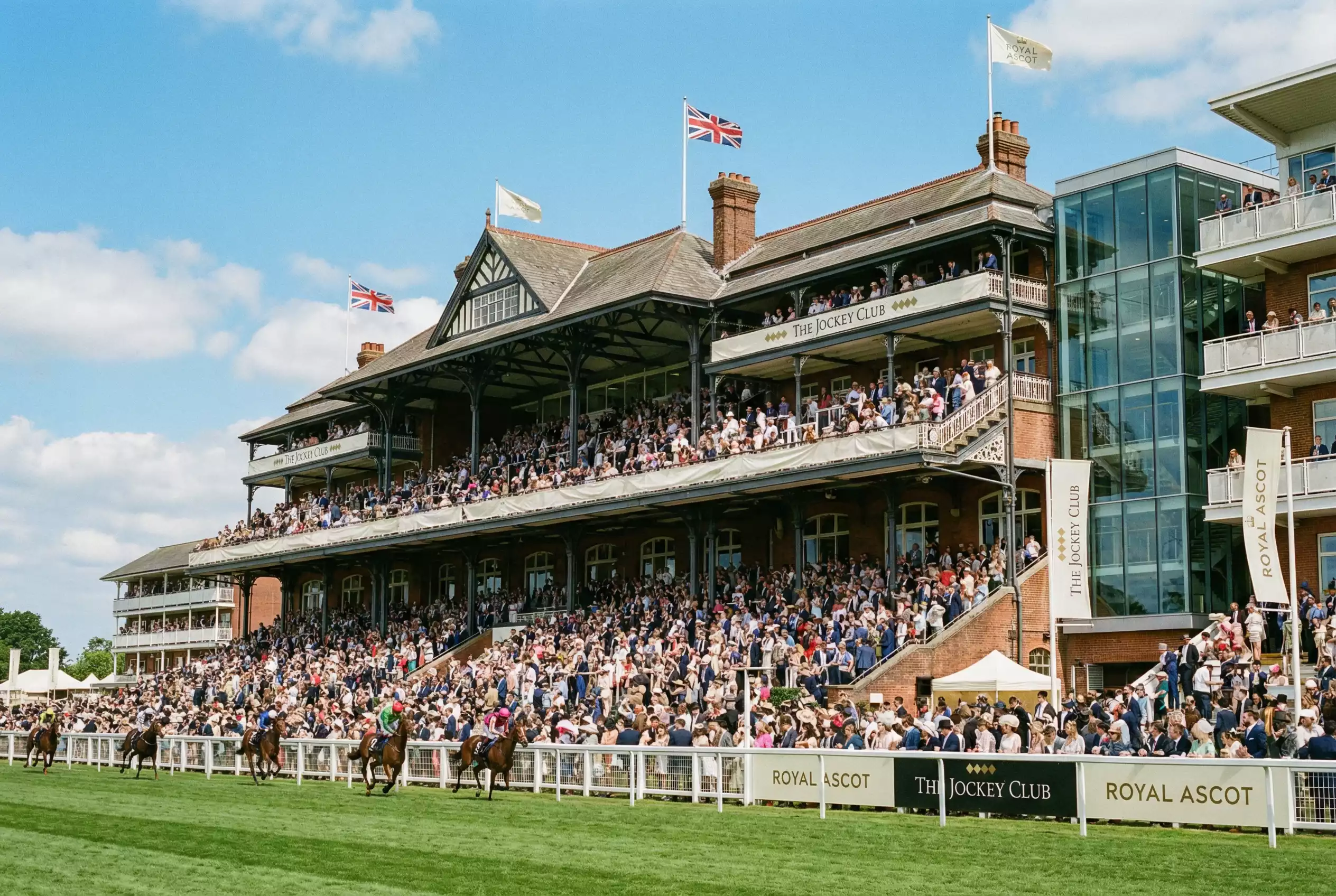 British racecourse grandstand with spectators watching horse racing