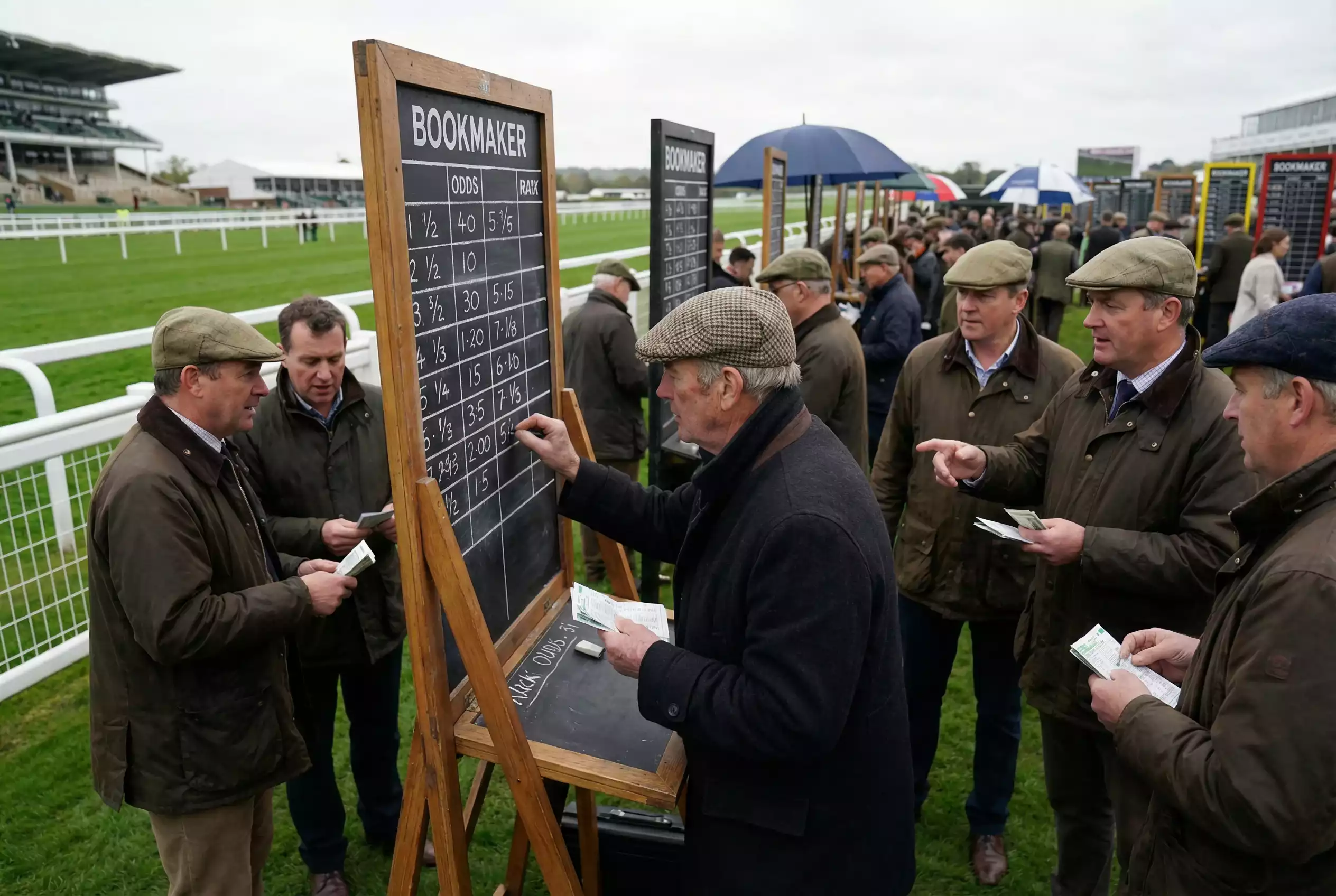 Traditional on-course bookmaker at UK racecourse with odds board and betting ring atmosphere